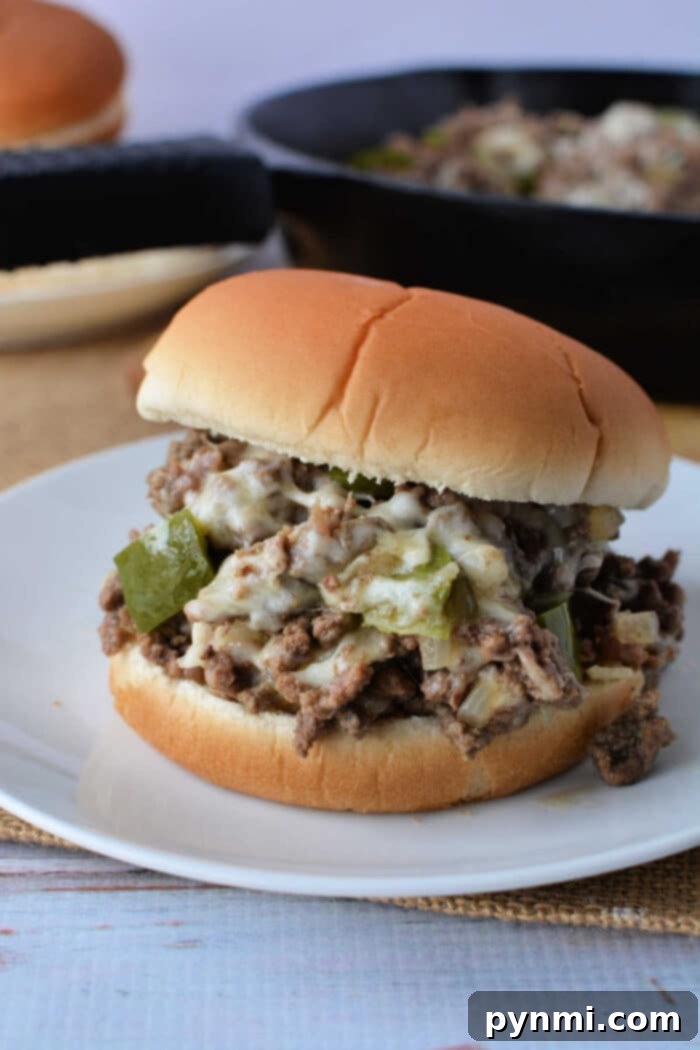 Philly Cheesesteak Sloppy Joes 6 Slow Cooker Philly Cheesesteak Sloppy Joes ready to be scooped onto buns, with melted cheese and vibrant vegetables.