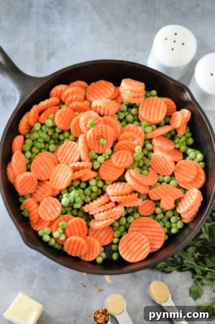Frozen Peas and Carrots being cooked in a microwave-safe dish