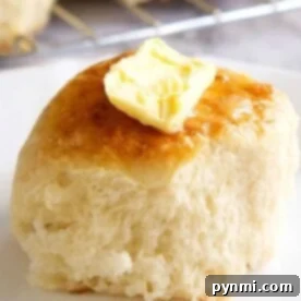 Bake Fluffy Frozen Rolls Easily 8 A buttered dinner roll on a plate, made even more delightful by starting with frozen rolls.