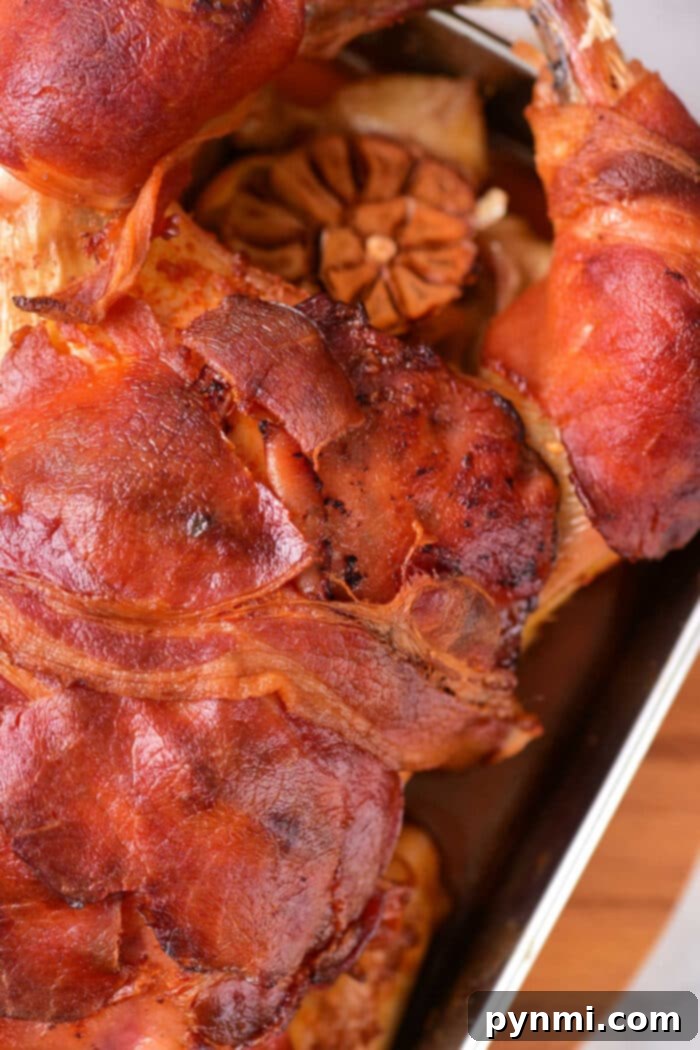 Gourmet Bacon-Wrapped Stuffed Chicken 5 Cooked whole chicken wrapped in bacon, resting in a roasting pan