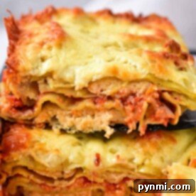 Ravioli Lasagna Bliss 7 Two slices of cheesy, baked lasagna stacked on a black spatula, showcasing layers of pasta, sauce, and cheese, capture the essence of comfort food reminiscent of homemade baked ravioli delights.