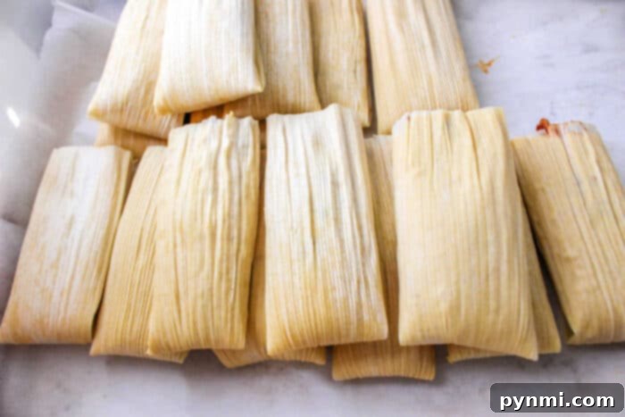 A close-up of tamales neatly arranged in a steamer, ready to be cooked. Learn the best methods for how long to cook tamales.