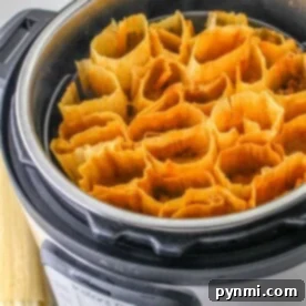 Tamales arranged in an Instant Pot, ready for steaming. Corn husks are neatly packed inside the stainless steel pot, as you ponder how long tamales take to cook to perfection.