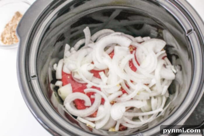 Sliced onions simmered with a splash of red wine in a slow cooker, alongside a bowl of chopped walnuts.