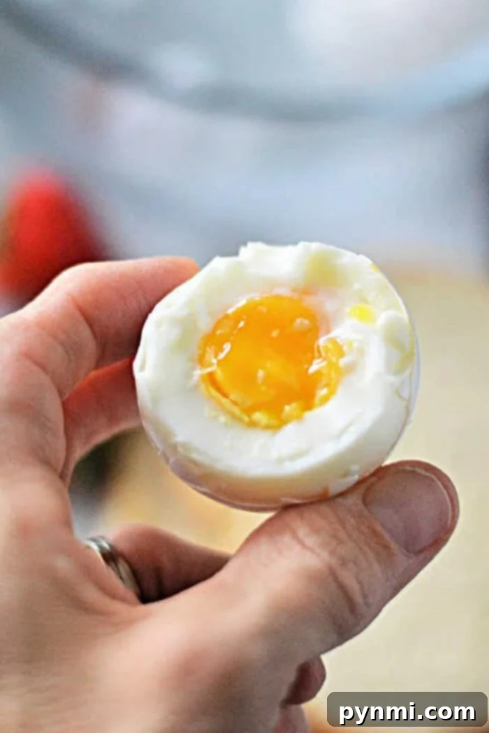 Perfect Soft Boiled Eggs Timing Guide 2 How Long to Cook Soft Boiled Eggs - A perfectly cooked soft-boiled egg on a spoon, ready to be enjoyed.