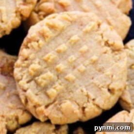 Close-up of peanut butter cookies with a crisscross fork pattern on top, perfectly baked to golden perfection. Wondering how long to bake cookies for that ideal texture? This delightful batch unveils the secret.