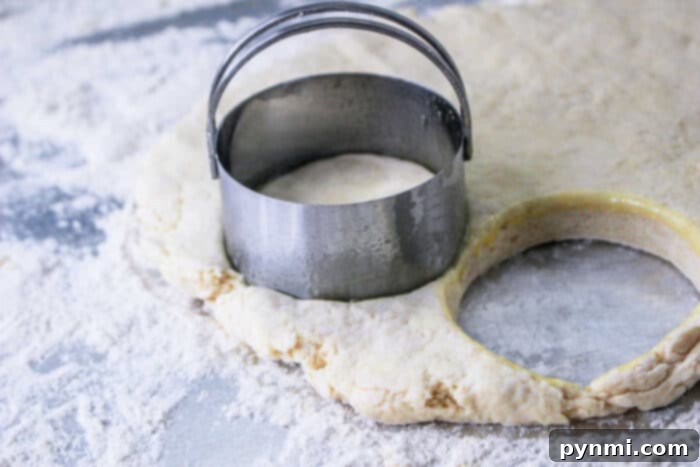 Biscuit dough from the Hardees Biscuits recipe is shaped with a round cutter on a floured surface.