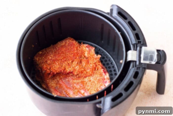 Crafting Irresistible Lamb Ribs 4 Crispy Air Fryer Lamb Ribs, seasoned with a dry rub, arranged neatly in an air fryer basket.