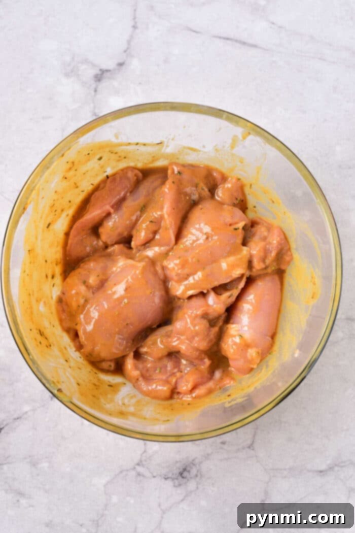 Grilled Chicken Thighs Marinade, showing marinated chicken thighs in a bowl.