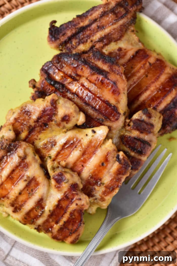 How Long to Grill Chicken Thighs - cooked grilled chicken thighs served with fresh herbs.