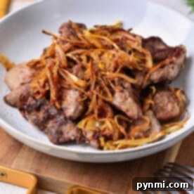 Expertly cooked liver, garnished with crispy fried onions, ready to serve as a delicious organ meat dish.