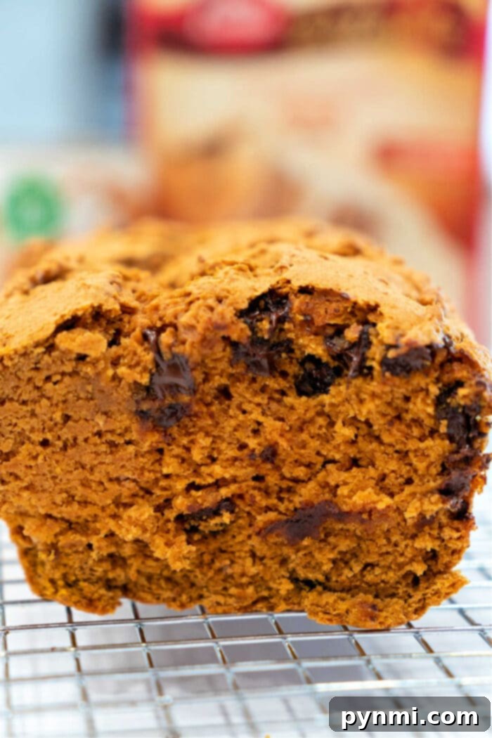 Golden brown loaf of pumpkin bread made with spice cake mix, ready to be sliced and enjoyed.