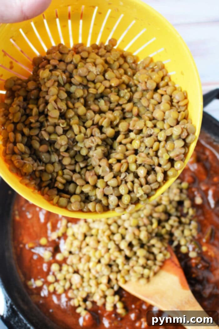 Cooking green lentils on the stove, showing a pot simmering with a spoon, highlighting the ease and versatility of stovetop lentil preparation.
