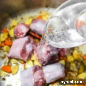 Learn how to make pho broth by pouring water into a pot filled with succulent meat, fresh carrots, and hearty potatoes.