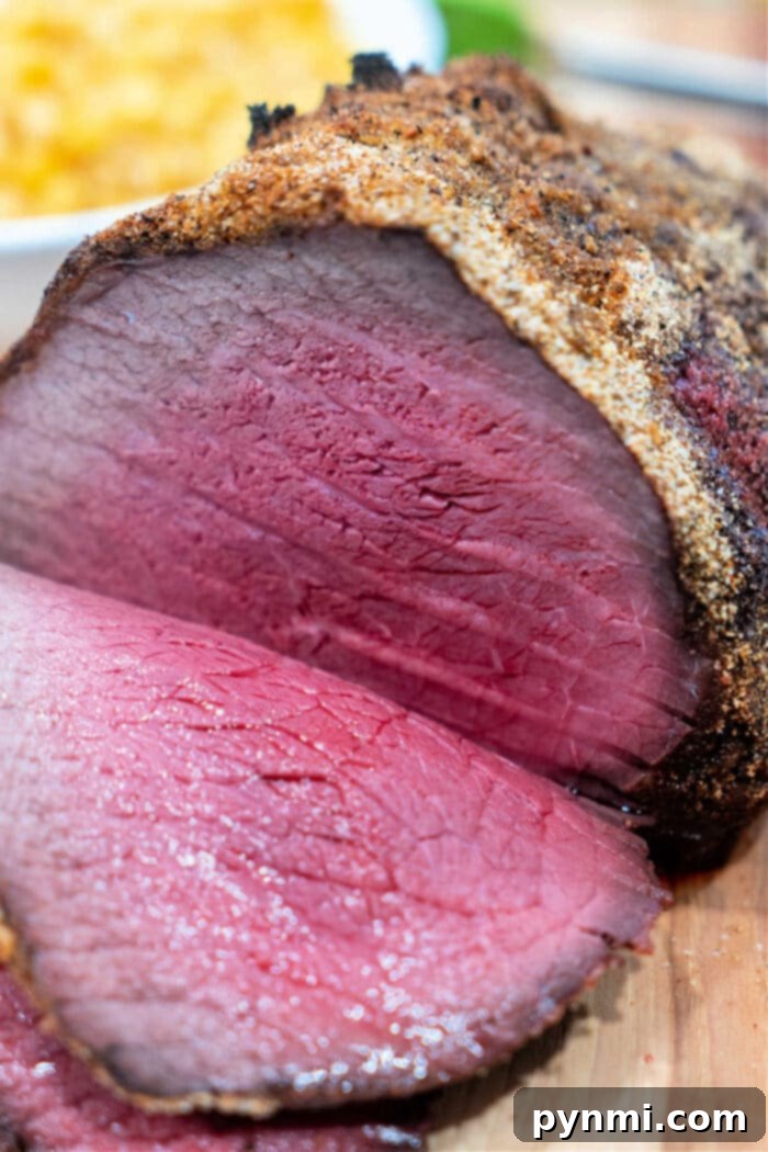 Never Overcook Your Roast Again 4 A perfectly cooked top round roast, expertly sliced to reveal a desirable pink interior, garnished and presented beautifully.