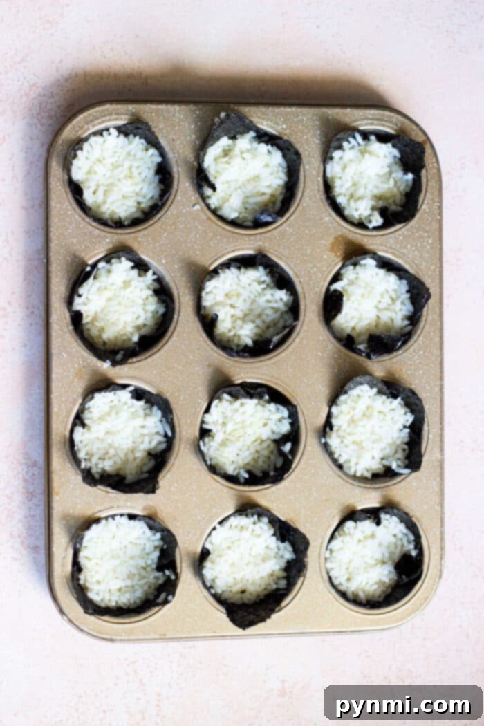 Salmon Sushi Bites 4 Close-up of baked salmon seaweed cups, showing the cooked salmon and rice with garnishes.