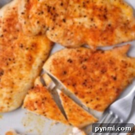 Grilled chicken breast slices are served on a plate with forks, seasoned perfectly with spices. Curious about cooking? If youre wondering how long to cook thin chicken breast in the oven, precise timing ensures juicy and flavorful results.