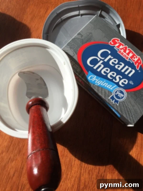 Save money by refilling premium plastic containers with bulk or cheaper alternatives Hands refilling a clean plastic container with cream cheese from a bulk package