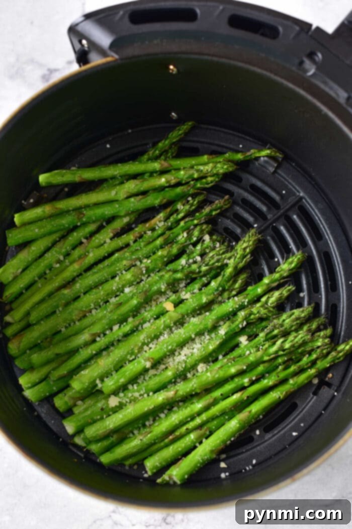 Ninja Foodi Air Fryer Asparagus on a plate, garnished with fresh herbs