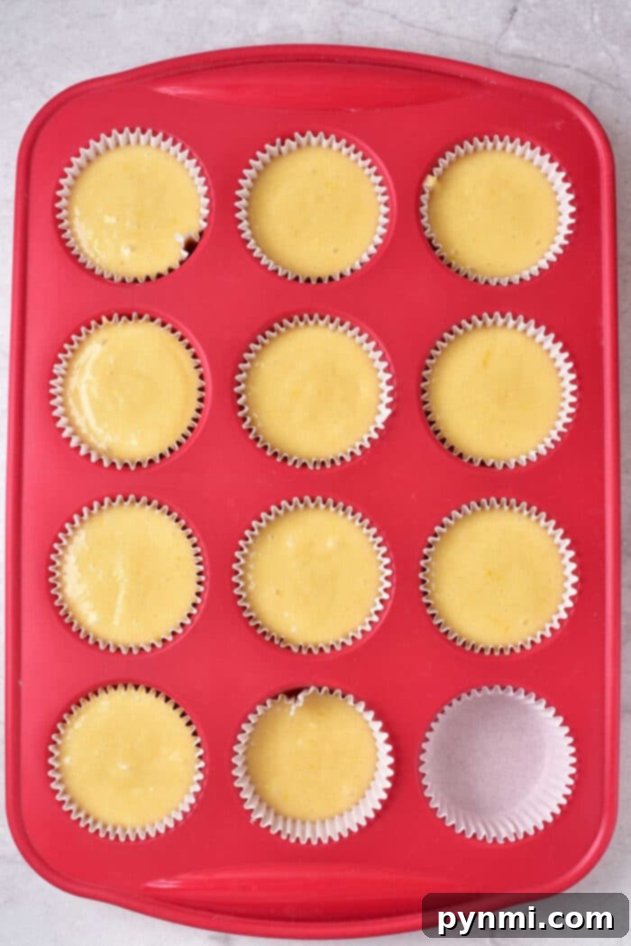 Sunshine Lemon Muffins 5 A selection of lemon muffins, some with glaze, on a white plate