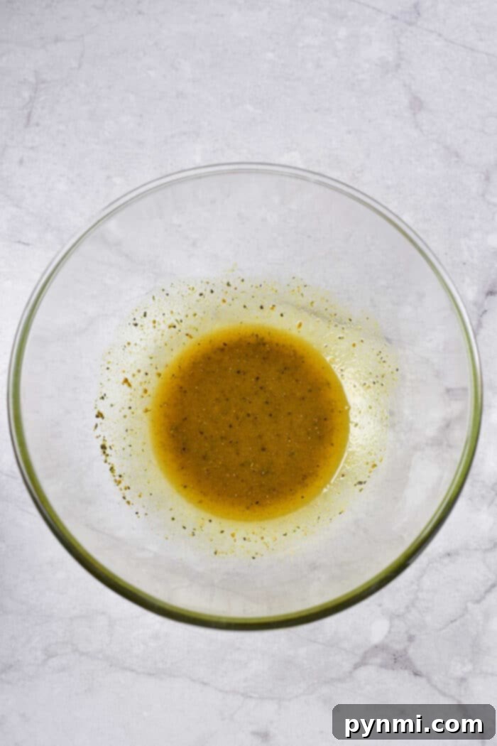 A close-up shot of a bowl filled with luscious honey lemon pepper sauce, ready to coat the crispy chicken wings.