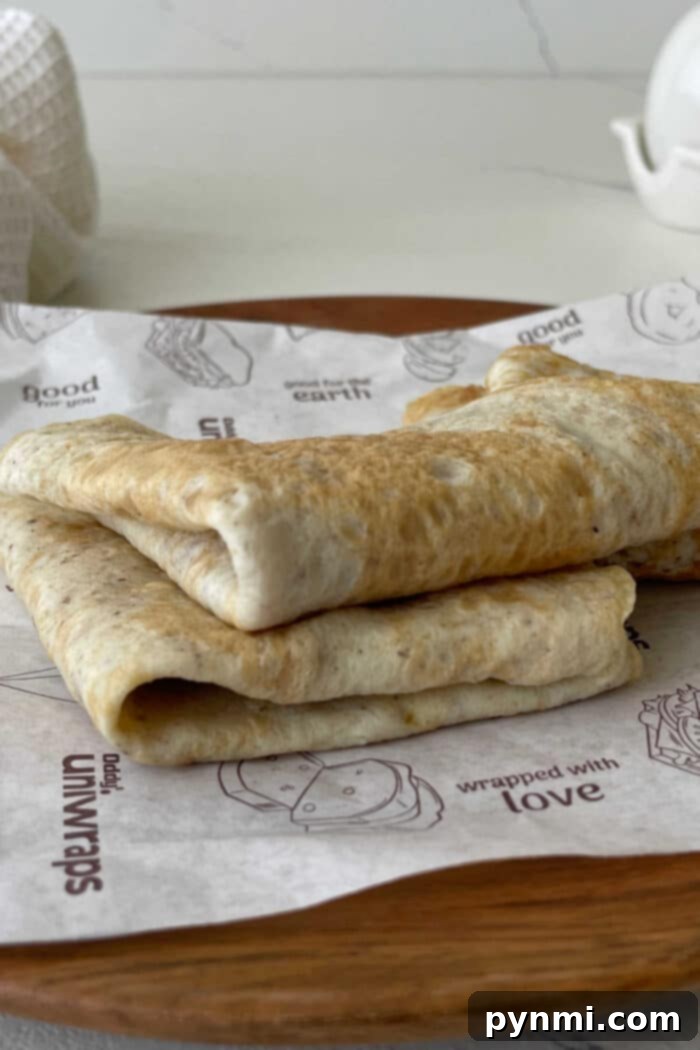 A beautifully presented stack of golden egg white tortillas on parchment paper, ready to be used or stored for future healthy meals.