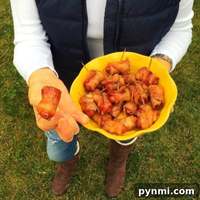 Great salty and sweet appetizers with bacon that are great for super bowl parties, get togethers or as a side dish. The best recipe for cocktail wieners. #bacon #smokies #sweet #brownsugar #hotdogs #best #appetizers #wieners A hand offers a delicious bacon-wrapped hot dog from a yellow serving bowl, inviting guests to enjoy this savory and sweet treat.