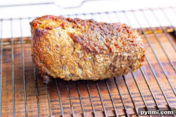 Achieving the Perfect New York Strip Roast 6 New York Strip Roast with Dry Rub, served on a cutting board