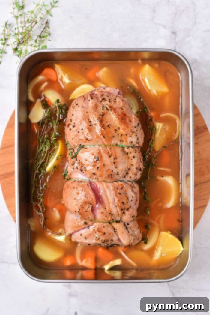 Succulent Lamb Breast Secrets 4 Roasted lamb breast in a pan, accompanied by carrots, potatoes, and herbs on a wooden board. For those seeking variation, consider exploring a tender lamb breast recipe that pairs beautifully with similar earthy accompaniments.