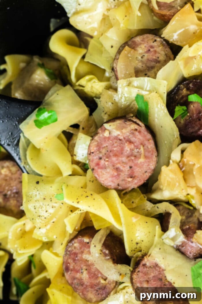 Effortless Slow Cooker Haluski 6 A large serving of traditional Haluski recipe, featuring golden egg noodles, tender cabbage, and savory kielbasa sausage, ready to be enjoyed.