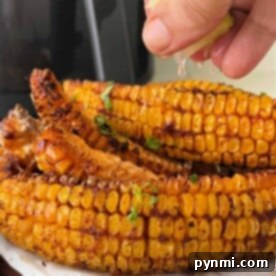 Corn on the cob ribs, with a hint of spice and a squeeze of lime, lays temptingly on parchment paper, reminiscent of a delightful corn ribs recipe.