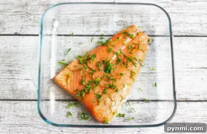 Optimal Salmon Baking Time 350 4 A raw salmon fillet, seasoned with chopped herbs.