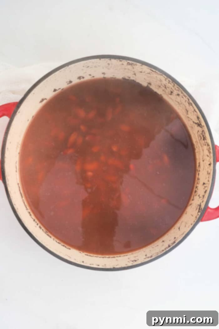 From Dry to Delicious: Cooking Kidney Beans 6 A slow cooker filled with simmering red kidney beans, illustrating the low-and-slow cooking method.