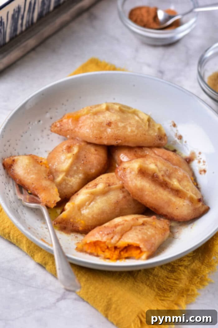 Golden Sweet Potato Dumplings 5 A batch of baked sweet potato dumplings glistening with cinnamon sugar glaze, in a ceramic baking dish.