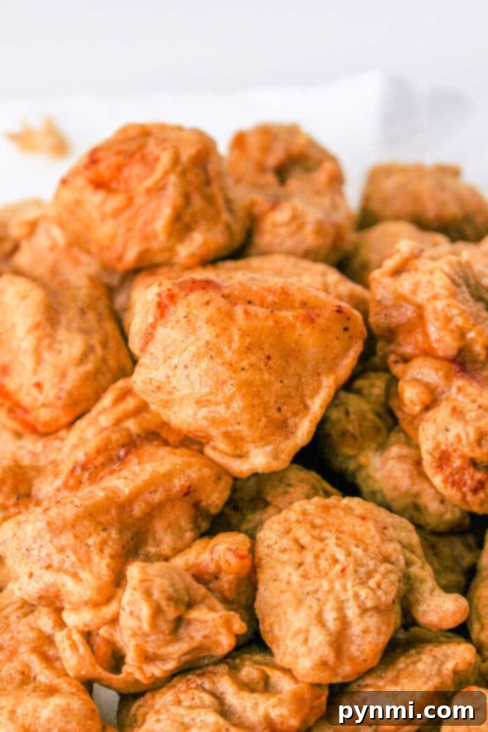 A close-up view of beautifully fried tempura chicken nuggets, perfectly golden and crispy.