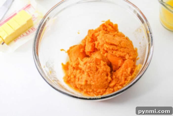 Sweet Potato Casserole with Canned Sweet Potatoes baking in a glass dish, showing the delicious filling before the topping is added