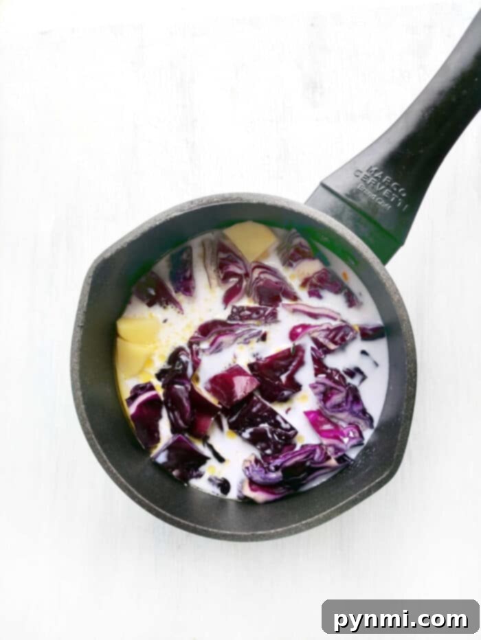 A close-up of a bowl of creamy pureed vegetable soup, showcasing its rich texture and inviting color.