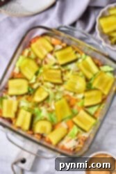 Ultimate Big Mac Bake 10 Big Mac Casserole topped with sliced pickles and lettuce in a glass baking dish.