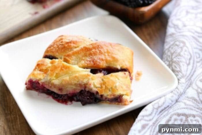 Sweet puff pastry strudel with fruit filling, ready to be sliced and served for breakfast or dessert.