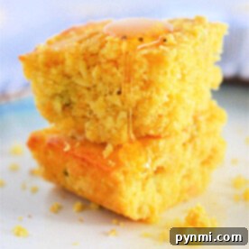 Two pieces of dairy-free cornbread stacked on a plate, drizzled with honey.