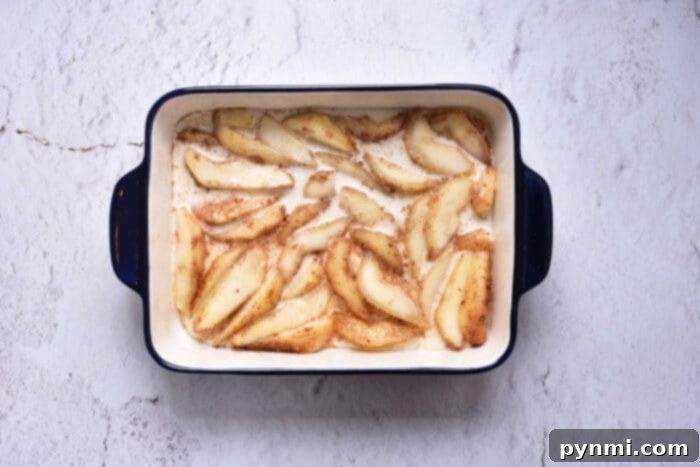 An array of beautifully arranged fresh pear slices, ready to be layered for a homemade pear upside down cake, emphasizing natural ingredients.