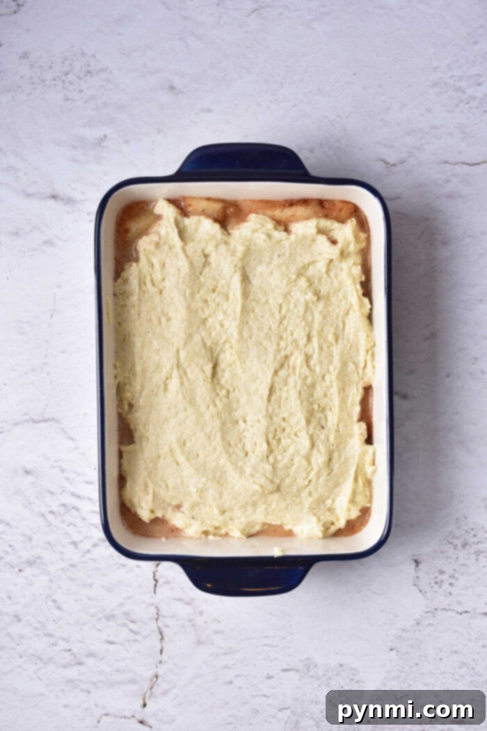 The vibrant texture of a fresh pear cake, with a golden-brown crust and visible tender pear slices peeking through, highlighting its homemade appeal.