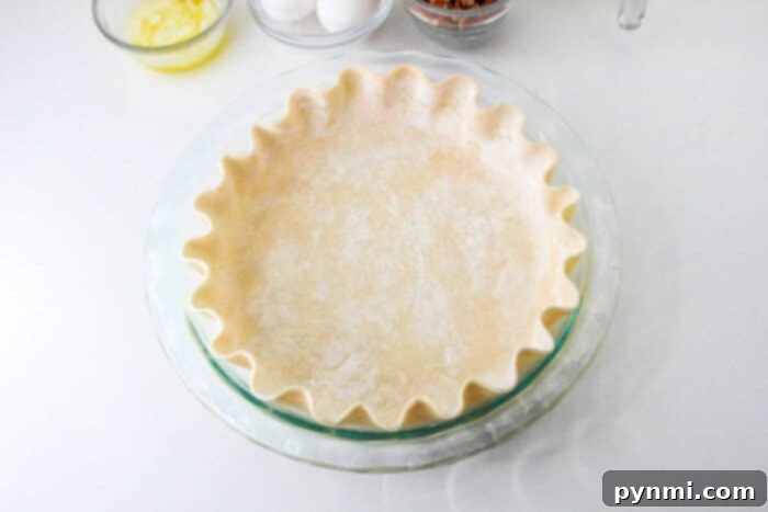 Golden-brown pie crust ready for filling, symbolizing the perfect start to a delicious homemade pumpkin pecan pie.