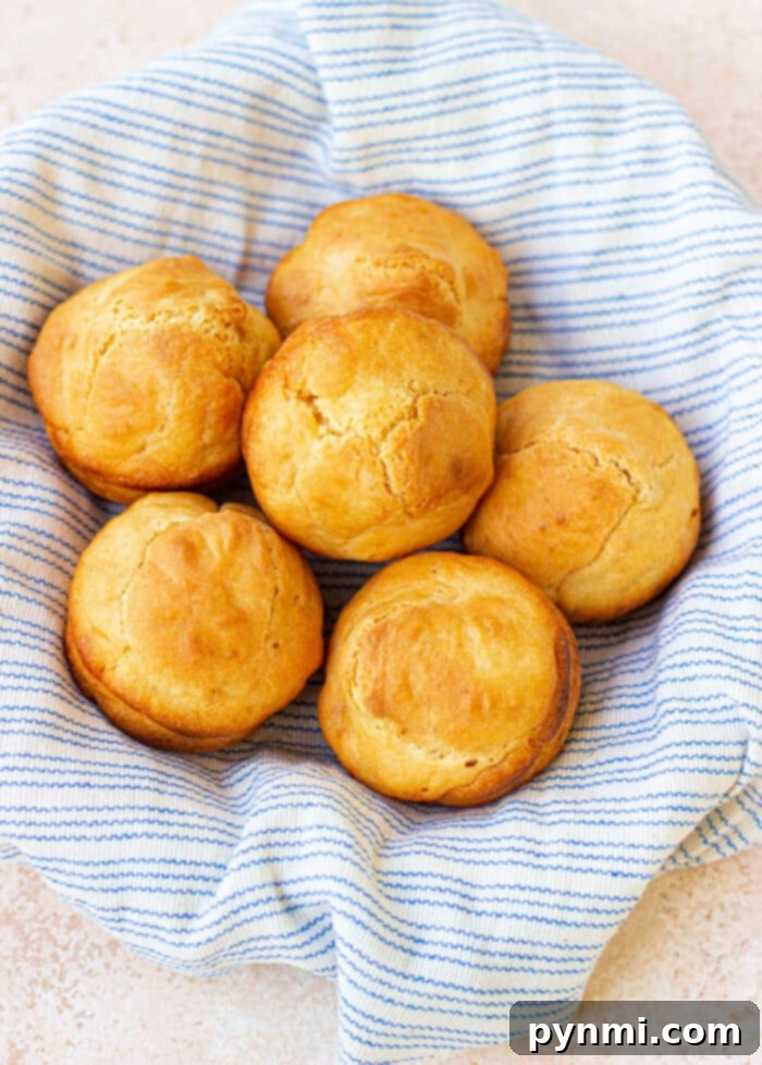 Golden-brown mayonnaise biscuits baked in a muffin tin, showcasing their fluffy texture.