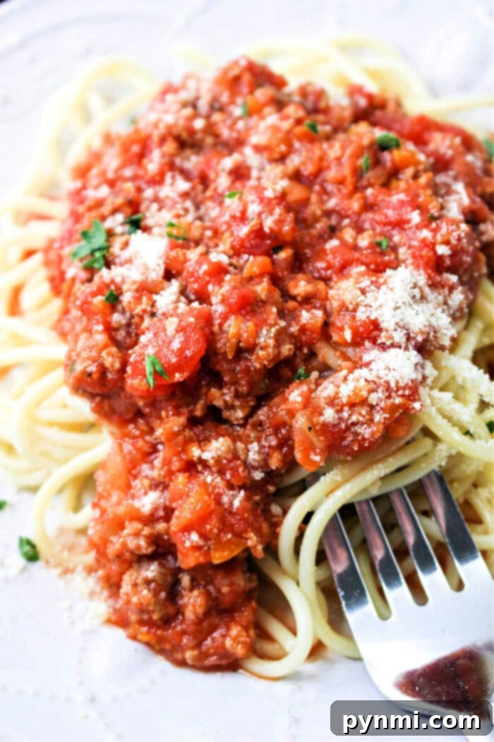 A large pot of homemade healthy spaghetti sauce simmering on the stove.