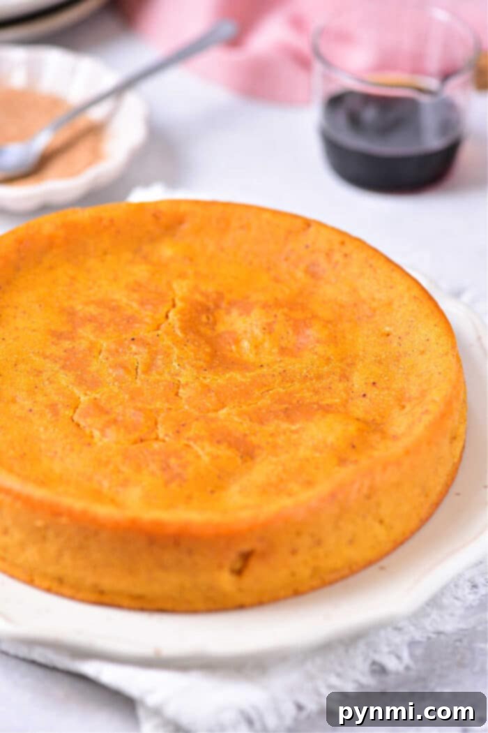 Impossible Pumpkin Pie, showing a full pie ready to be sliced, garnished with a sprinkle of cinnamon or nutmeg.