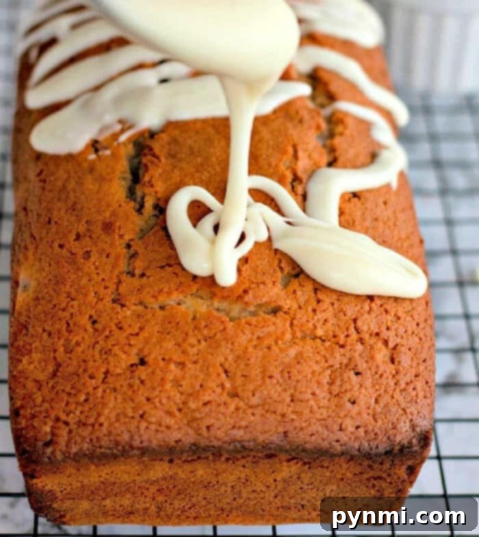 Sweet Cherry Loaf 2 Maraschino Cherry Bread, a vibrant pink loaf with white glaze, on a cooling rack, ready to be enjoyed.