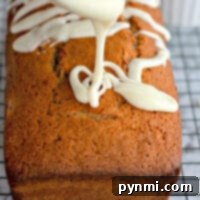 Maraschino Cherry Bread, with rich icing drizzling over the loaf cake on a cooling rack, creates a tantalizing display.