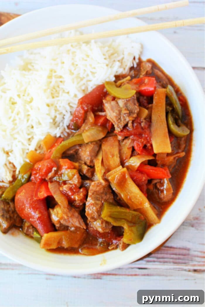 Tender Slow Cooker Pepper Steak with Gravy, served with rice
