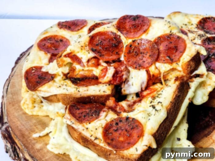 Various slices of Pizza Grilled Cheese, some with pepperoni, some plain cheese, on a cutting board.